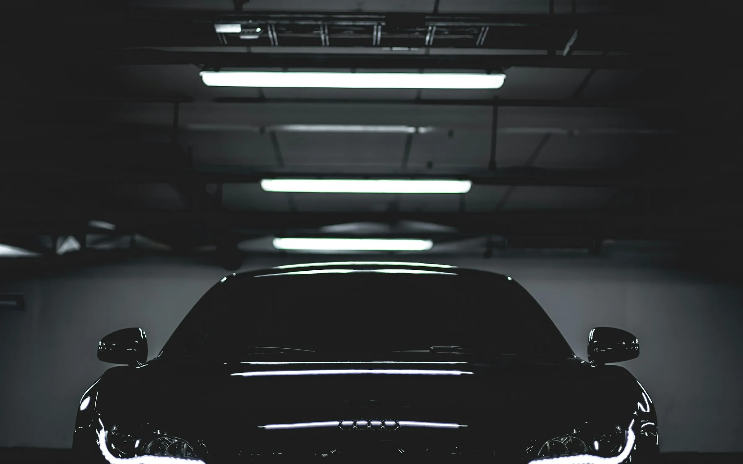 Black luxury car under showroom lights