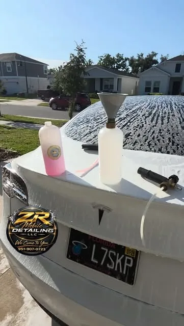 Foam pre-wash on a white Tesla in a Kissimmee driveway